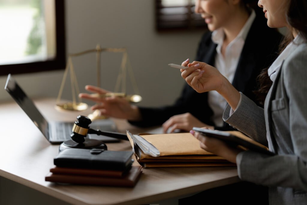 Abogadas revisando documentos con mazo y balanza simboliza qué hacer si mi seguro no me quiere pagar por un accidente.