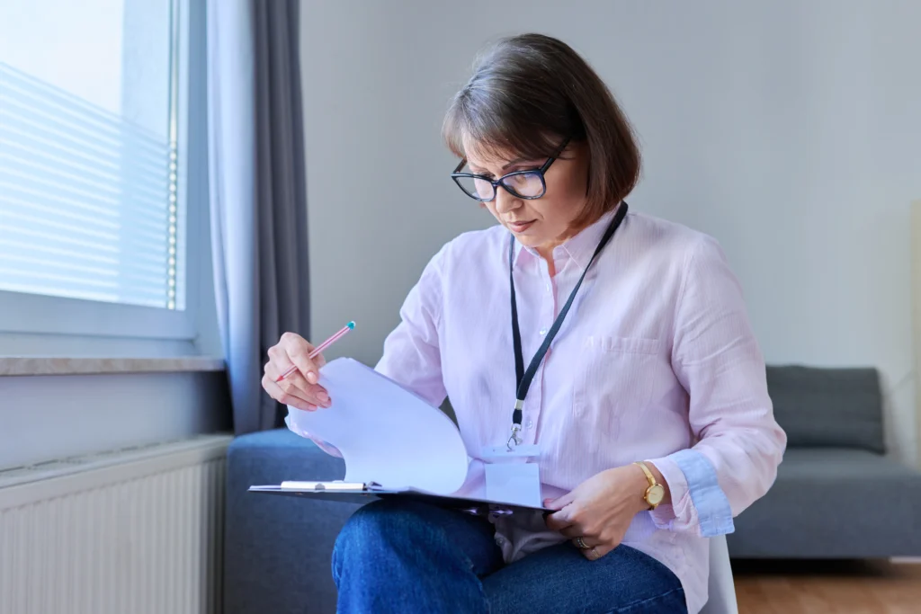 Toma fotográfica de mujer haciendo chequeo de su papeleo para poder quitarse de dudas sobre.. ¿Tu seguro de gastos médicos rechazó el pago? Esto puedes hacer