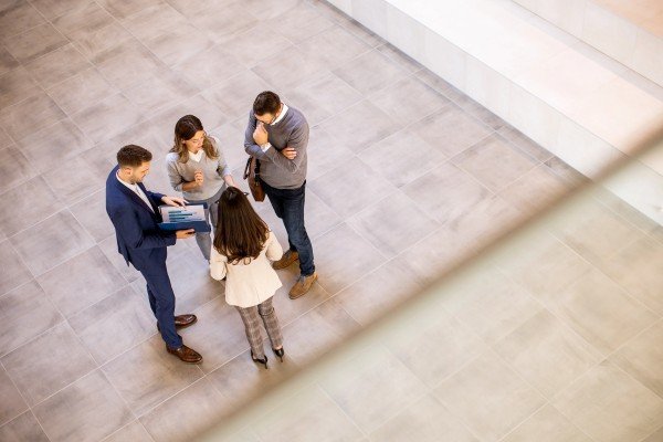 Toma visual de 3 herederos y 1 abogado tratando de solucionar los problemas legales más comunes al comprar una propiedad