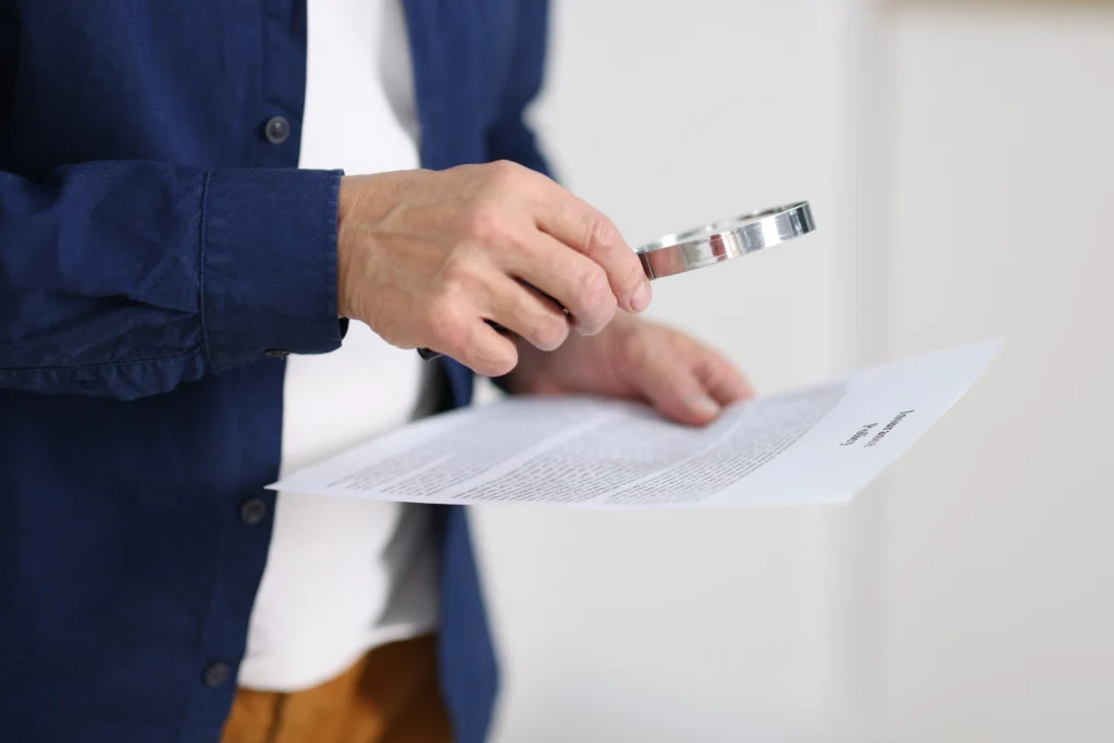 Imagen de un colaborador experto en checar documentos, leyendo con detenimiento un contrato y así poder evitar clausuras abusivas en póliza de seguro de un cliente