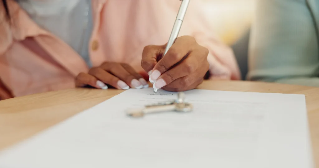 Imagen de una chica con camisa rosa leyendo todas las clausulas que protegen tu empresa en contrato de arrendamiento para no tener futuros problemas