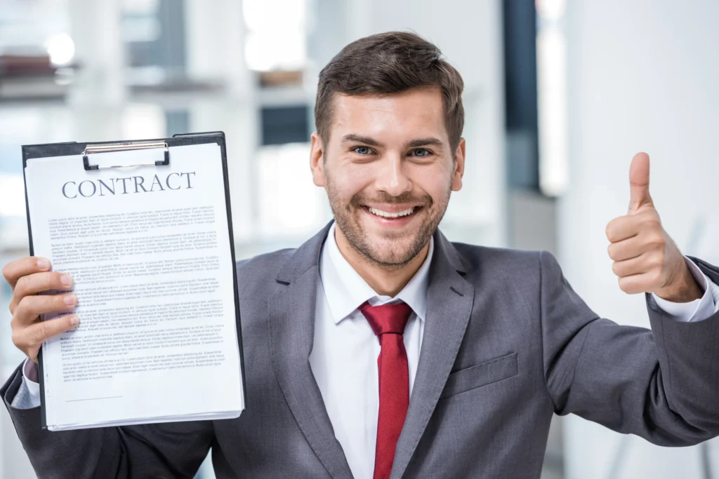 Contrato de compraventa de inmueble: Imagen de un hombre feliz con contrato en mano porque asistió con L&L para que lo ayudaran con su problema