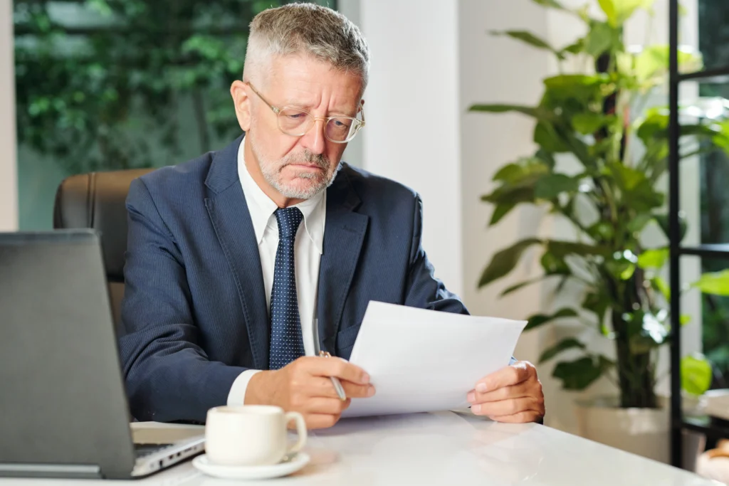 Qué es la CONDUSEF: Empresario leyendo un documento que se le envió por escrito el cual es su respuesta de rechazo por parte de su aseguradora