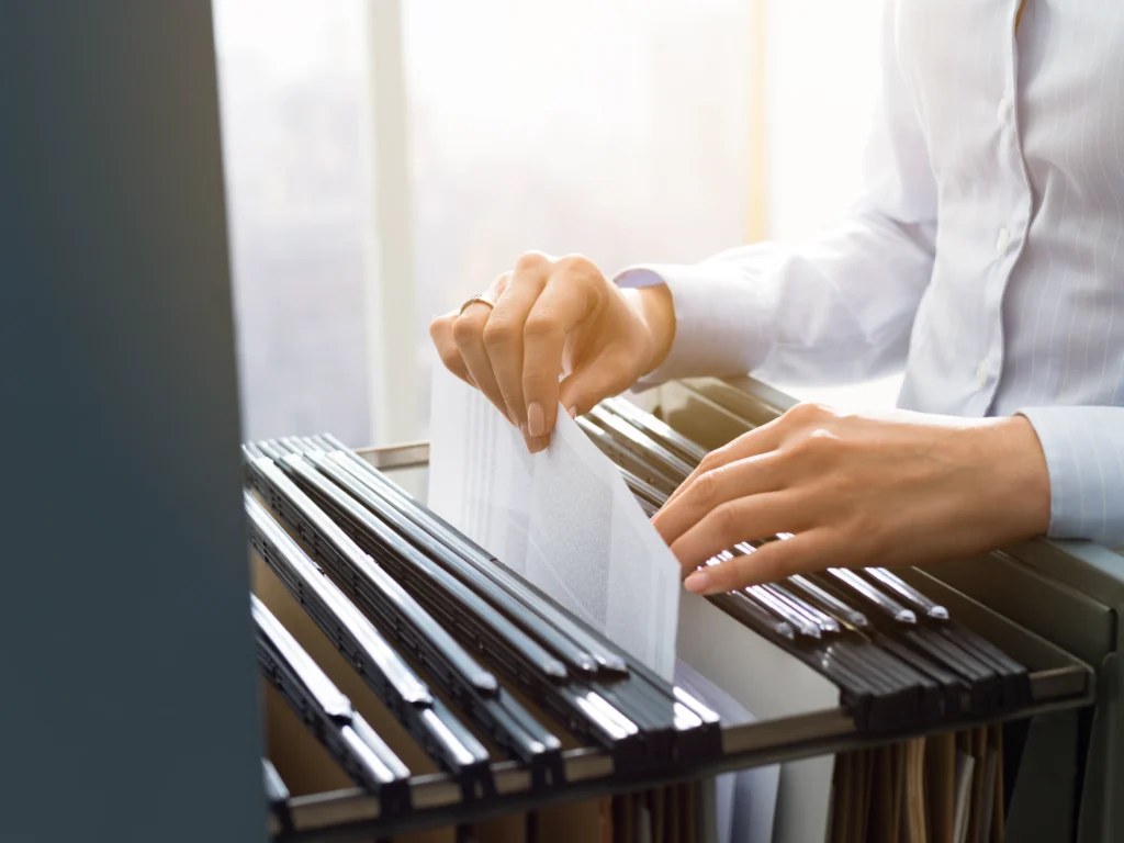 Regularización de propiedades sin escrituras: Imagen de un hombre revisando archivos en el registro publico de la privacidad para evitar fraudes