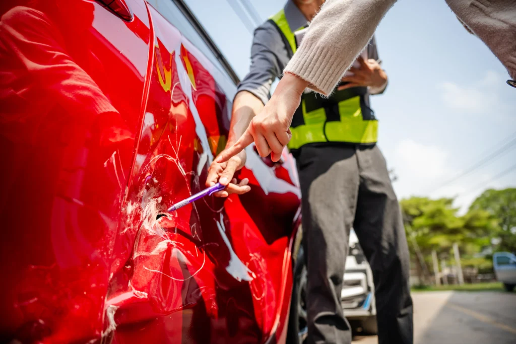 Seguro de daños a terceros en accidente de tránsito: Fotografía de las manos de un perito encargado de revisar a detenimiento cómo fue el accidente, señalando un choque que fue provocado a propósito